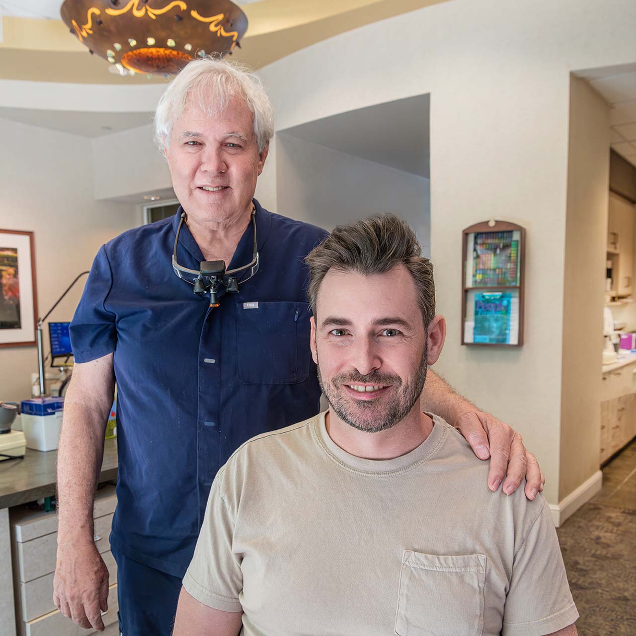 Happy patient with a beautiful smile, shown by Dr. Kelleher, thanks to Invisalign aligners.