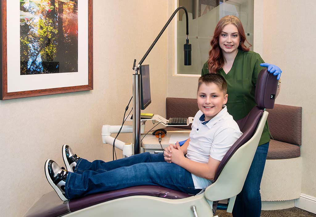 Kelleher Orthodontics patient, a smiling boy with metal braces, highlighting treatment options.