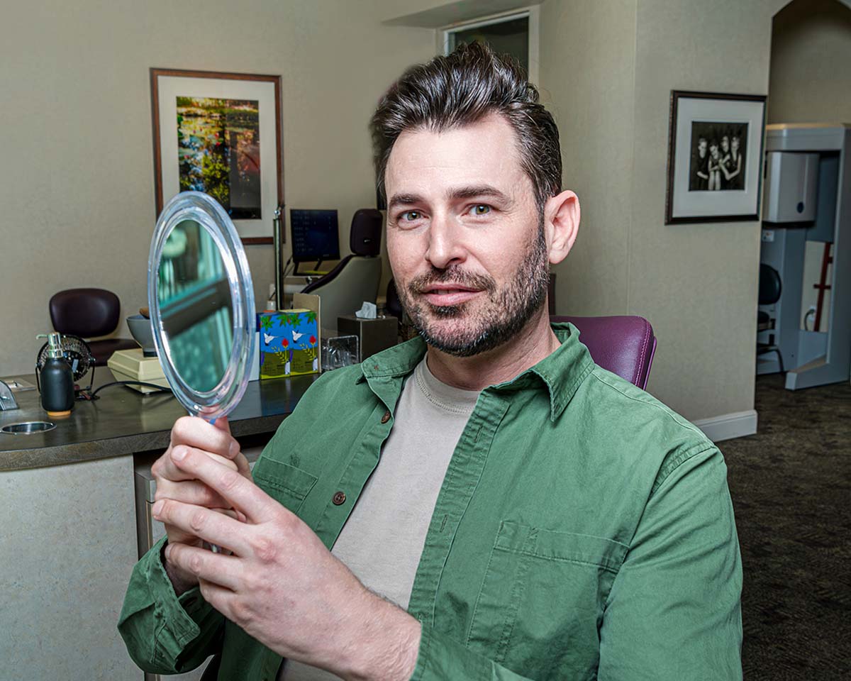Happy patient in an orthodontist chair getting started with their Invisalign treatment.