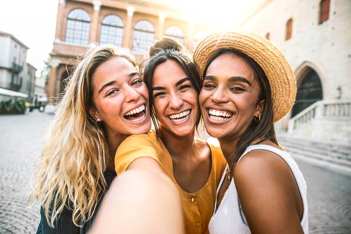 A group of women taking a picture while traveling, demonstrating how adult orthodontics can fit into a busy lifestyle.